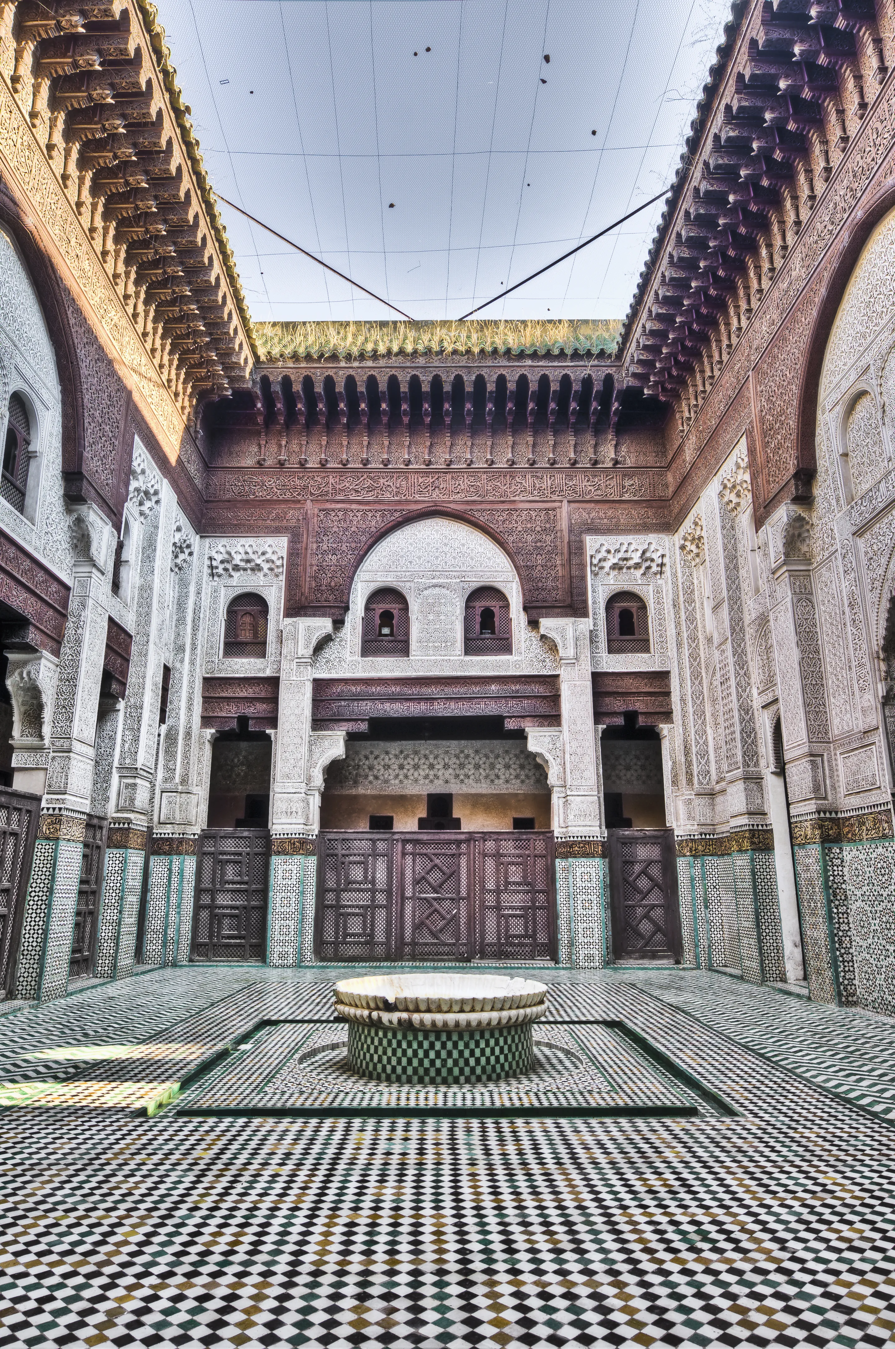 Historic Madrasa courtyard featuring authentic Moroccan Zellij tile floor